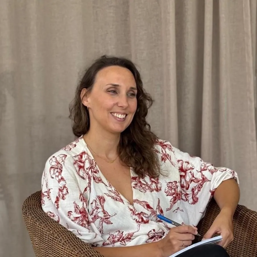 Léna Pronost, sophrologue, assise dans un fauteuil, regard doux et posé